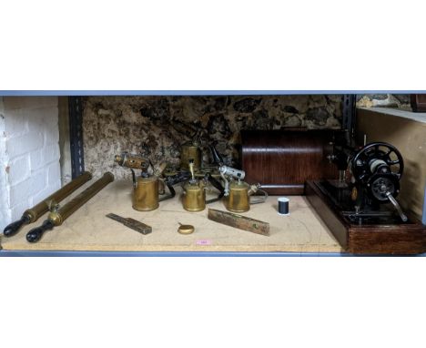 A selection of brassware and tools to include four brass cased blow lamps, two garden pumps, a wood and brass spirit level an