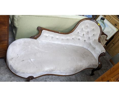 A Victorian carved mahogany framed and upholstered chaise longue on French cabriole carved front legs and ceramic castors Loc