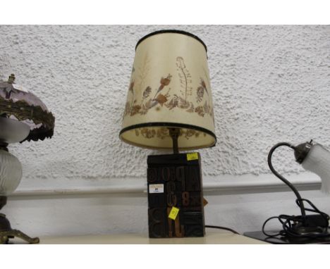 Decorative table lamp, base in the form of a printers block 