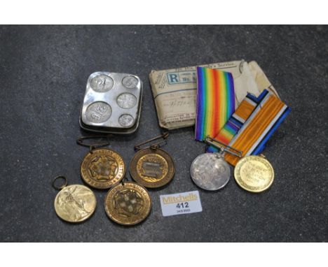 Three First World War medals, three education medals and a coin holder 