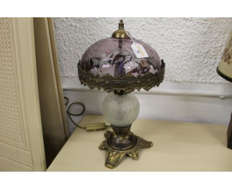 A decorative table lamp with dome glass shade, glass central body and metal foot 