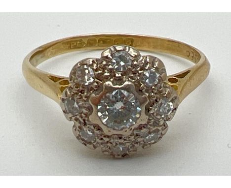 A vintage 18ct gold diamond cluster style ring set with 9 round cut diamonds. Total diamond approx. .70ct. Full hallmarks to 