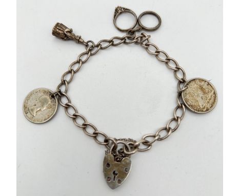 A vintage silver charm bracelet with 4 charms, padlock and safety chain. Charms include wedding and engagement ring and Canad