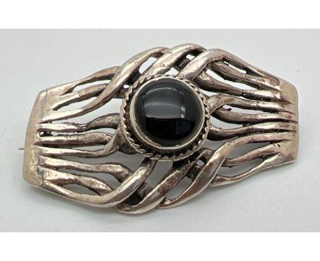 A silver knot design brooch set with a central round cabochon of black onyx. Silver marks to back. approx. 4.5cm x 3cm. 