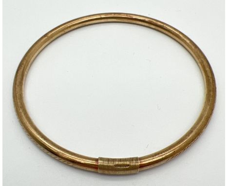 A vintage 9ct gold bangle with engraved floral pattern. Bangle has been repaired and strengthened with 9ct gold wire. Hallmar