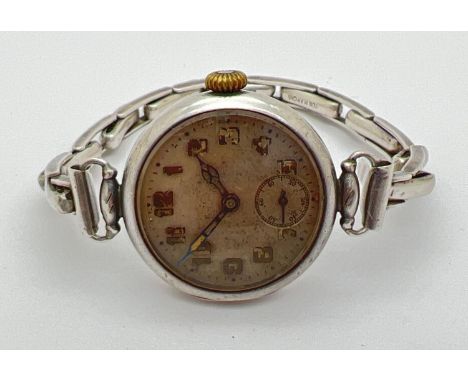 An antique silver WWI military wristwatch by Rolex. Fitted with a replacement sterling silver Bon Marche expanding strap. Sil