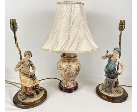 3 table lamps. A pair of ornamental figural lamps featuring a blacksmith &amp; a cobbler, on wooden plinth bases (no shades),