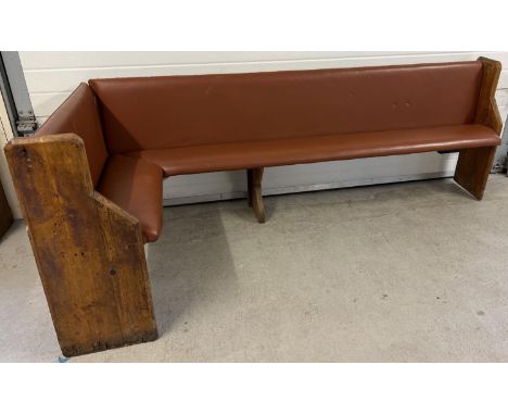 A corner bench seat as taken from a local pub, originally made from antique pews. Covered in tan coloured studded leather uph