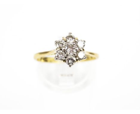 An 18ct gold and diamond cluster ring. The seven round brilliants approx. 0.80cts total, all claw set in white on a yellow D-