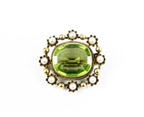 A late Victorian gold, peridot and half-pearl oblong brooch. Centred with a cushion-shaped peridot measuring approx. 16.5mm x