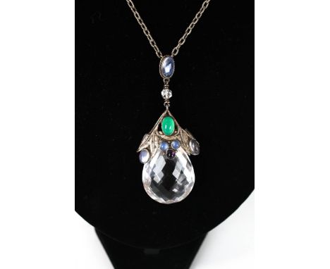 An Arts and Crafts rock crystal and gem set pendant. The large faceted rock crystal drop (approx. 37mm high), suspended from 