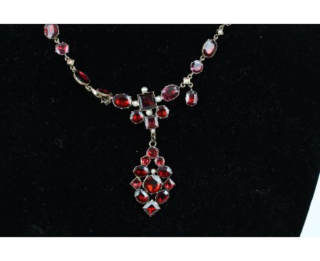 A late 19th century gold, half-pearl and flat-cut garnet collet necklace in 18th century style. In the form of a line of alte