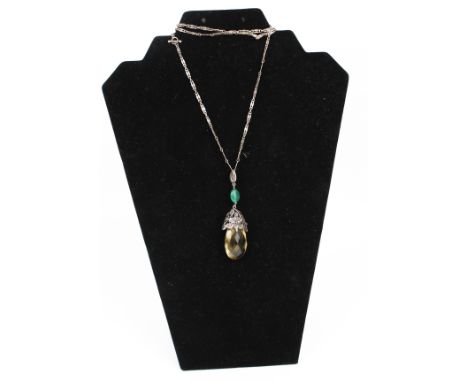 An Arts and Crafts citrine and gem set pendant. The large faceted citrine drop (approx. 38mm high), suspended from a smaller 