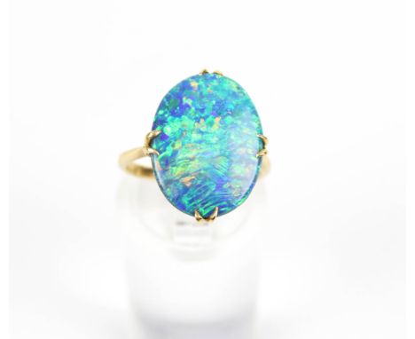 An oval opal-doublet single stone ring. The flat panel measures approx. 17mm x 13mm x 3.7mm, displaying a pleasing play of mo