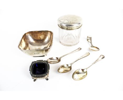 A small collection of silver including a rounded-square sugar bowl. With tapering sides engraved at one corner with script in