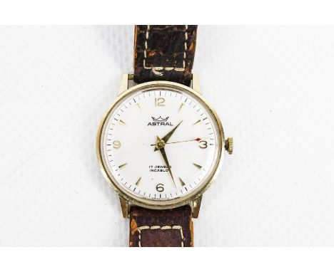Astral, a gentleman's 9ct gold cased round wristwatch, circa 1976. The silvered dial with raised gilt arrow-head indicators a