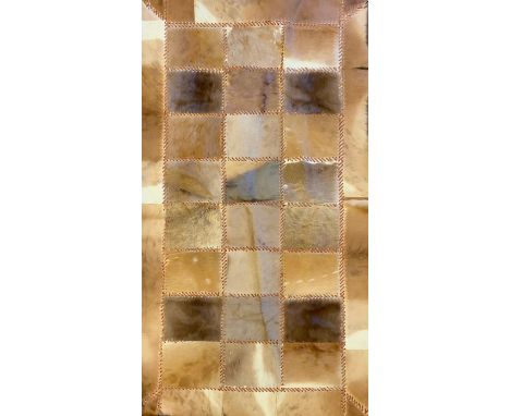 A patchwork cow hide rug/tapestry, leather bound, 87cm x 153cm 
