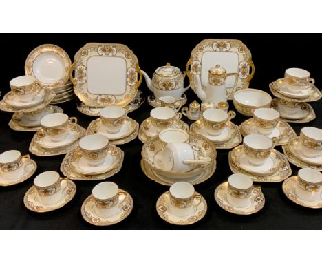 A Noritake gilt cream and white table service inc coffee pot, coffee and tea cups ans saucers, cruet set on stand, etc. 