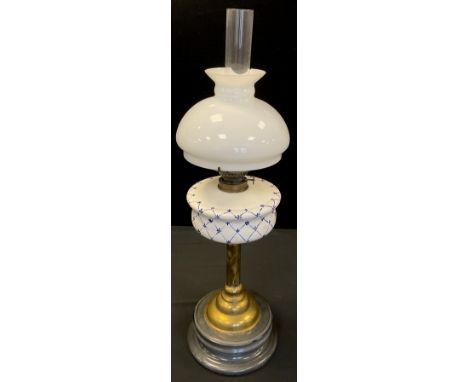 An early 20th century brass oil lamp, blue and white ceramic reservoir, white glass shade, 71cm high. 