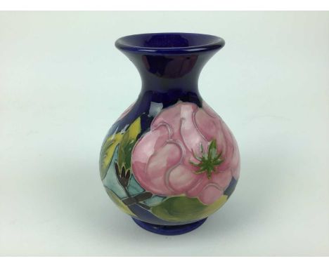 Moorcroft pottery vase decorated in the Magnolia pattern on blue ground, impressed marks to base, 13cm highCondition report: 