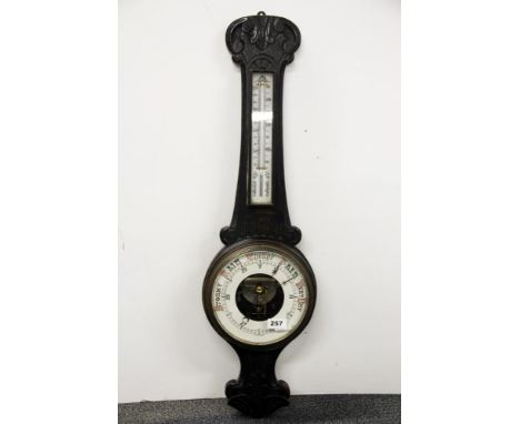 An ebonised carved wooden barometer, H. 84cm.