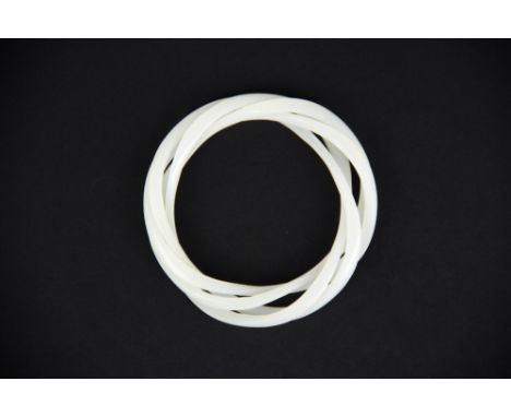 A rare Chinese carved white jade interlocking triple bangle.