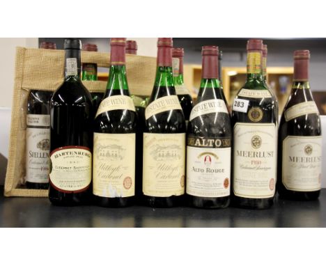 A group of 12 bottles of vintage South African red wines.