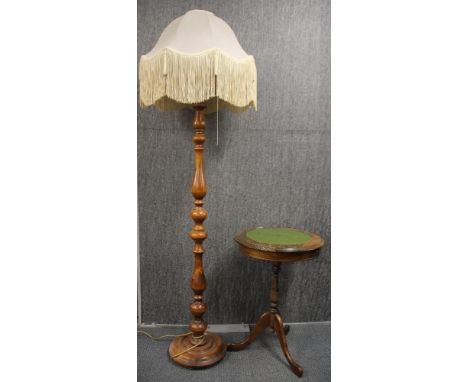 A leather topped wine table and a turned wooden standard lamp with shade.