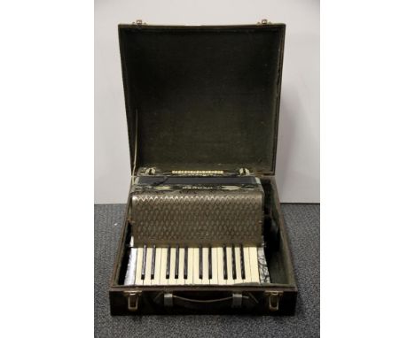 A cased vintage Hohner piano accordion.