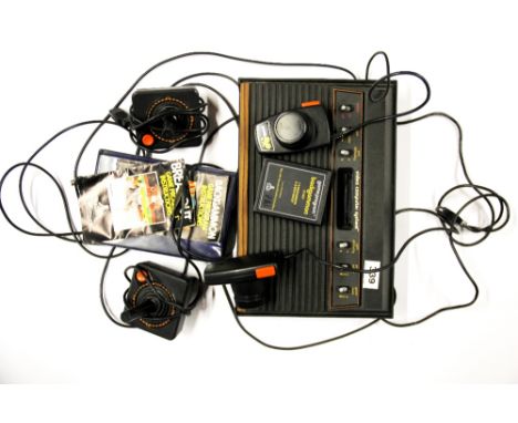 A vintage Atari video computer system with joysticks and paddles.
