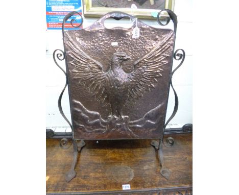 AN ARTS AND CRAFTS BEATEN COPPER FIRESCREEN, with wrought iron frame