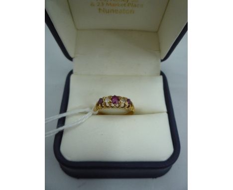 AN 18CT GOLD RUBY RING, with three rubies and two clear replacement stones to the fancy tapered shank, hallmarks for London, 