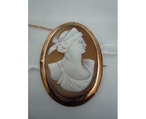 A CAMEO BROOCH, with classical carving of a women in profile within a rope twist border and further plain surround, stamped 9