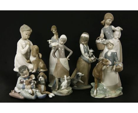 A collection of Lladro figures, to include a little boy cuddling newborn puppies, a girl holding a lamb, a girl playing with 