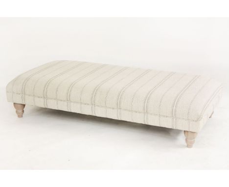 A contemporary oversized foot stool, with oatmeal grey striped upholstery and turned hardwood feet, 138cm x 75cm x 17cm