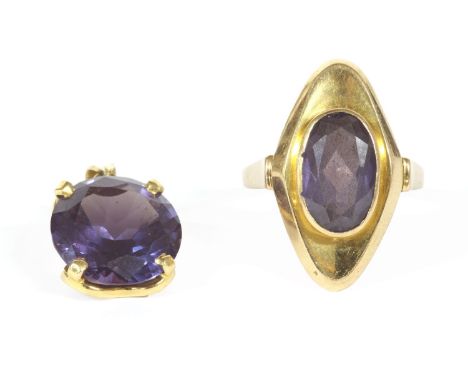 A gold single stone oval mixed cut synthetic colour change sapphire ring, rub set to a lozenge mount and plain polished shank