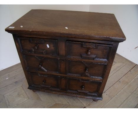 Small 19th C oak chest with step top above two short and two long drawers with Jacobean style panelled detail on raised bun f