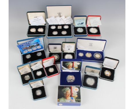 A large collection of Elizabeth II Royal Mint deluxe-format silver proof collectors' coins, including one pound four-coin set