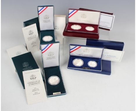 A large collection of USA United States Mint deluxe-cased silver proof dollar and half-dollar commemorative coin sets, includ