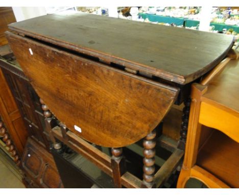 An Antique oak drop leaf table with bobbin turned legs, end frieze drawer.