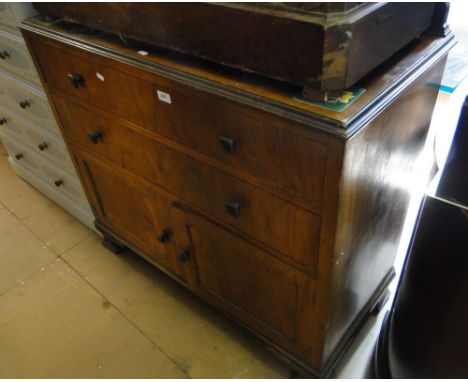 A walnut cabinet with drawer and cupboards on bracket feet.