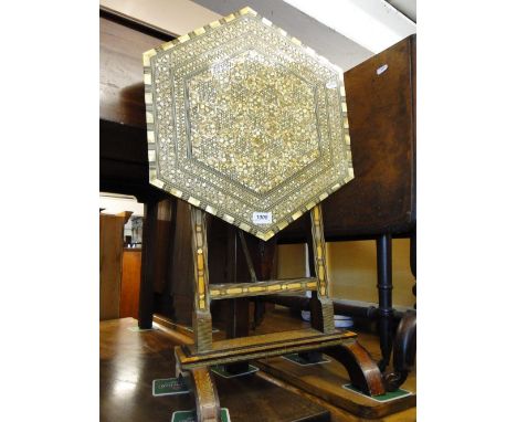 A mother of pearl effect decorated folding occasional table.