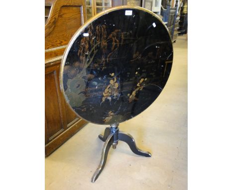 An Oriental black lacquered and chinoiserie decorated tilt top tripod table.