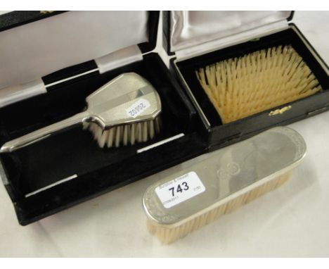 An engine turned silver backed brush and 2 other silver backed brushes.