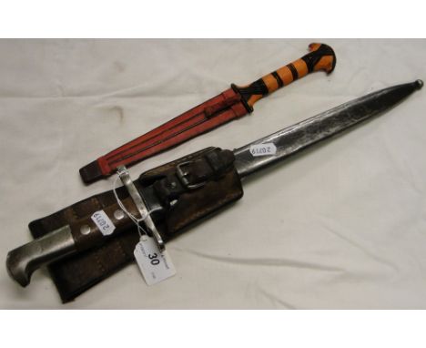 A bayonet in steel scabbard with leather holster and another knife.