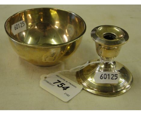 Small circular silver bowl and a squat silver candlestick.