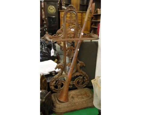 A cast-iron umbrella stand with drip tray and a copper hunting horn.