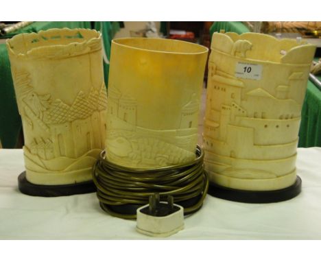 3 Ivory table lamps with carved designs of buildings.