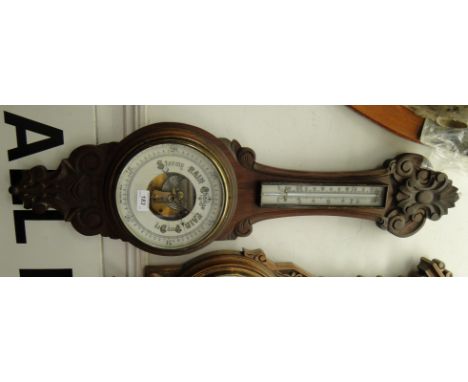 A carved mahogany case barometer with thermometer.