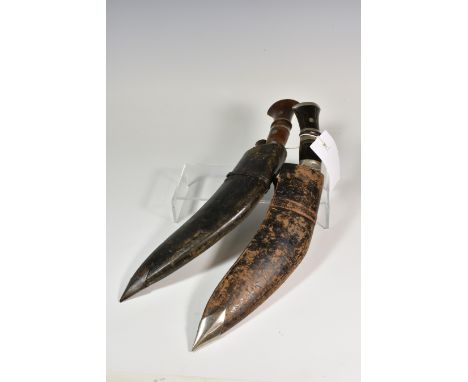 Two Kukri with leather scabbards and accompanying knives probably late 19th / early 20th century, the first with horn handle 